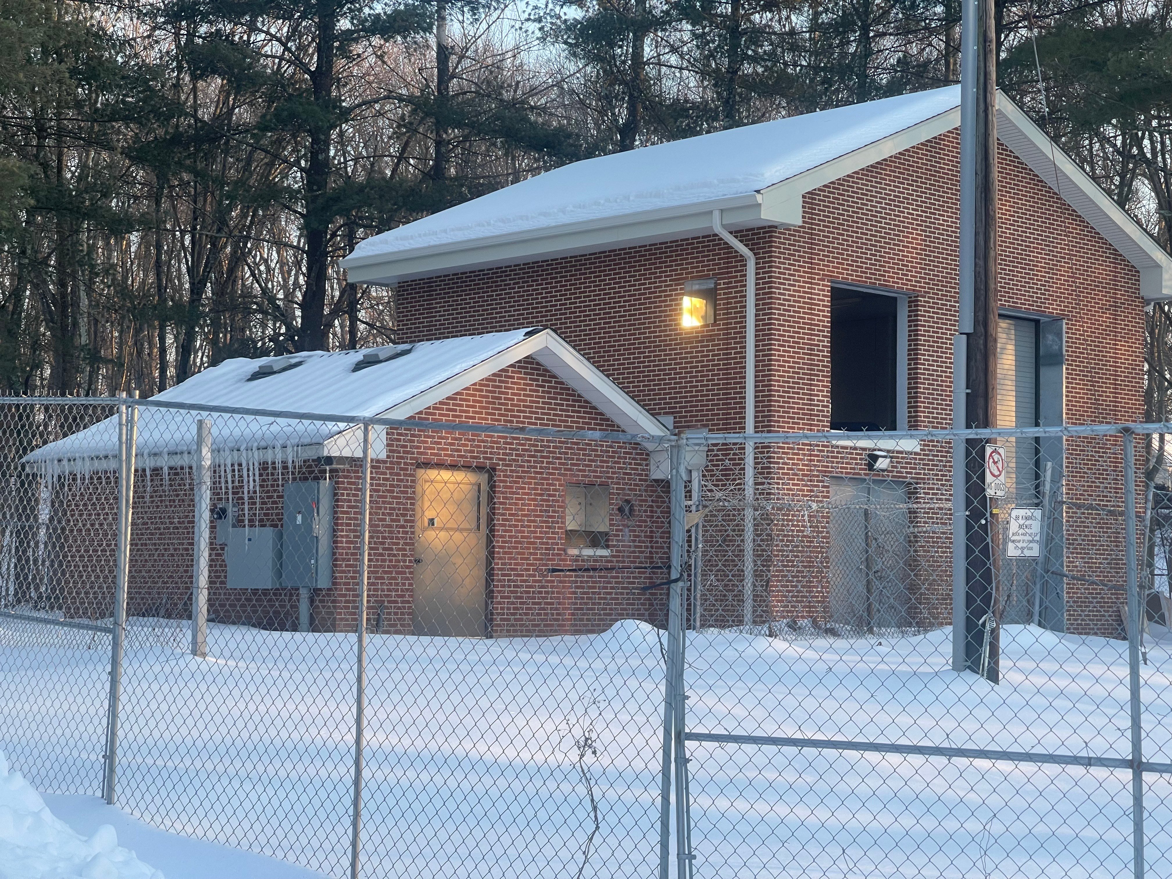 Well 10 pump house in Livingston, NJ - a brick building surrounded by snow and chain-link fence